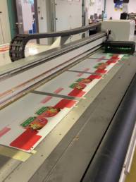 Imprimante Nyala 4 grand format en train d'imprimer des stop-rayon en rouge et vert